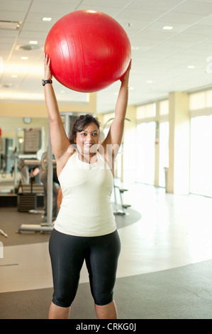 Donna con palla ginnica in palestra Foto Stock