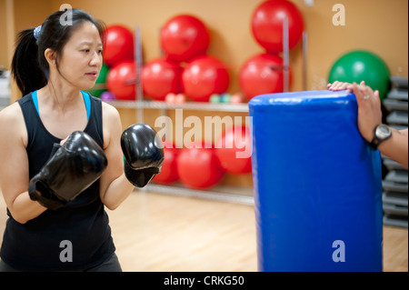 Donna sacco da boxe in palestra Foto Stock