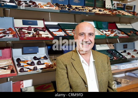 Ritratto di tabacco shop proprietario con tubi in background Foto Stock