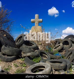 Croce di pietra e mucchio di pneumatici scartati, Auvergne-rhone-Alpes, Francia Foto Stock
