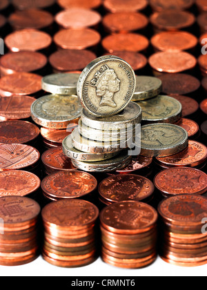 Ordinate cataste di British spiccioli con un palo di una libbra di monete Foto Stock