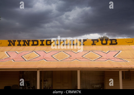 Nindigully Pub segno su ferro corrugato tetto con Castlemaine XXXX annuncio di birra scura cielo tempestoso Nindigully Queensland Australia Foto Stock