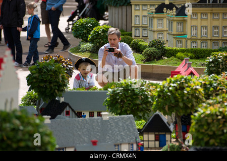 L'uomo con il suo figlio a scattare foto di case di Lego a Miniland, Legoland a Billund, Danimarca Foto Stock