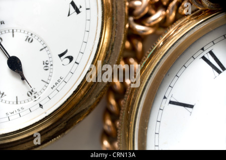 Due oro orologio con catena in oro un orologio ha numeri romani le altre cifre arabe e seconda linea Foto Stock