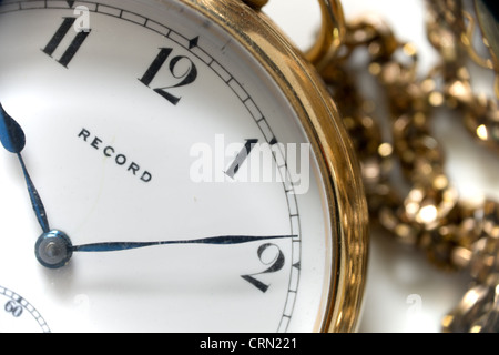 Un oro orologio da tasca da Record con numeri arabi e intricati catena d'oro in background Foto Stock