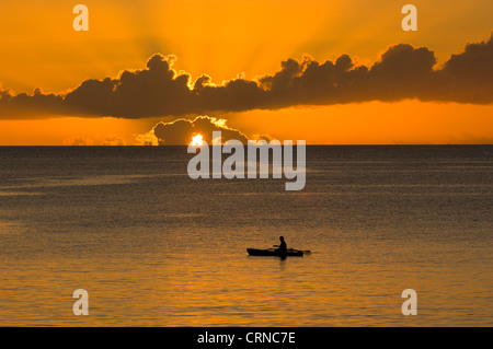 L'uomo la pesca da una canoa outrigger al tramonto, Isola di Pentecoste, Vanuatu Foto Stock