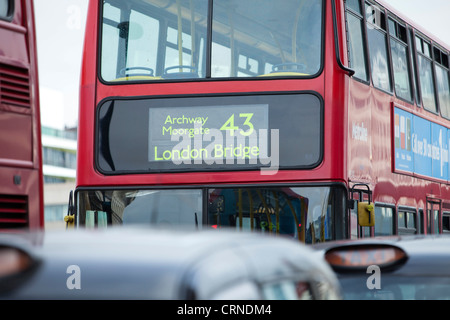 Londra taxi e un bus rosso a due piani in coda sulla London Bridge. Foto Stock