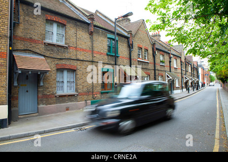 Un nero Londra taxi viaggiano lungo Copperfield Street nel quartiere londinese di Southwark. Foto Stock