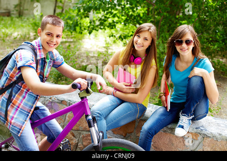 Ragazzo sulla moto fermarsi accanto a due belle ragazze Foto Stock