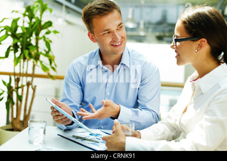 Consulente sorridente preferendo la moderna tecnologia a forme obsolete di fare business Foto Stock