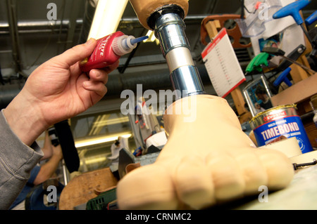 Un tecnico la costruzione di una protesi gamba in una protesi workshop. Foto Stock