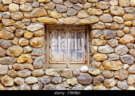 Isole Baleari muratura muro di pietra con grunge finestra di legno Foto Stock