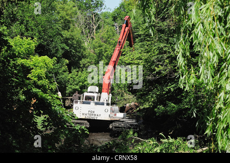 Sgombero gru detriti di canale da un incolto canal off the Fox River nel nord dell'Illinois. Foto Stock