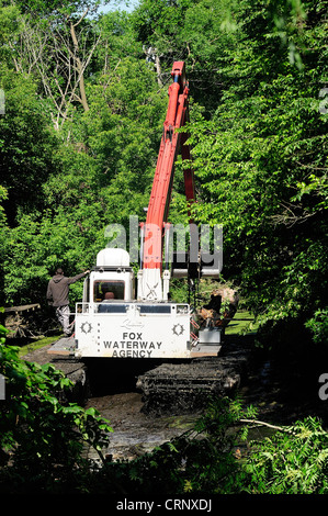 Sgombero gru detriti di canale da un incolto canal off the Fox River nel nord dell'Illinois. Foto Stock