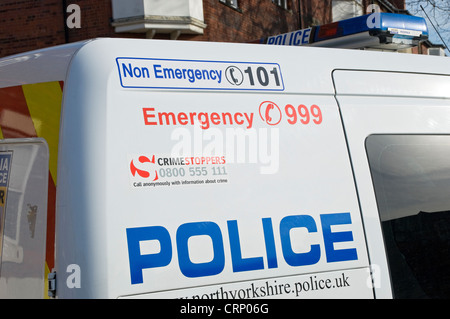 Emergenza e non i numeri telefonici di emergenza sul lato di una polizia van. Foto Stock