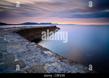 Sunrise over 'il Cobb', una parete del porto che ha permesso di Lyme Regis a diventare un importante porto dal XIII secolo in poi. Foto Stock