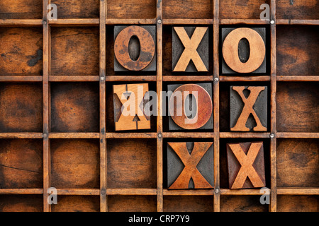 Tic-tac-punta o di una partita di tris gioco - vintage tipografia blocco X e o in legno typesetter grunge box Foto Stock