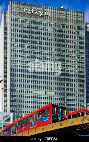 Un DLR (Docklands Light Railway) treno passa davanti di J.P. Morgan merchant bank uffici in Docklands. Foto Stock