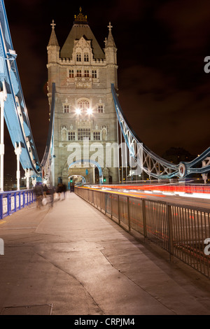 La gente e il traffico che attraversa il Tower Bridge di notte. Foto Stock