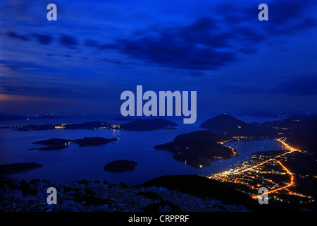 Panoramica vista notturna di Vlychos bay e Nydri città dalla montagna Skaroi, Lefkada (o 'Lefkas') isola, mare Ionio, Grecia Foto Stock