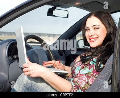 La bellezza della donna con argento laptop seduto in macchina Foto Stock