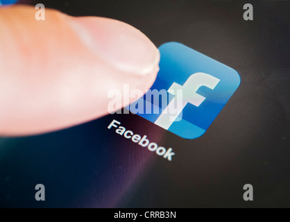 Utilizzando Facebook app su un computer tablet iPad Foto Stock