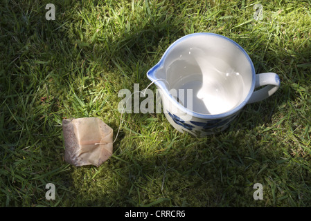 Un gettato un sacchetto da tè manca la coppa fu gettato a terra e sull'erba Foto Stock