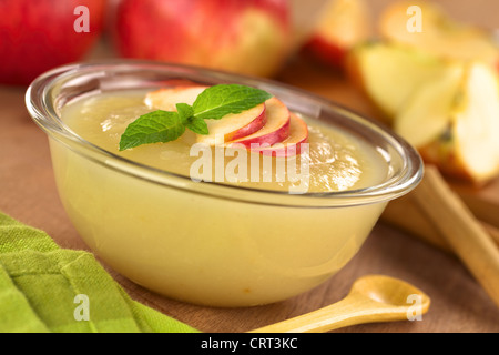 Freschi Fatti in casa la salsa di apple in recipiente di vetro con le mele nella parte posteriore Foto Stock