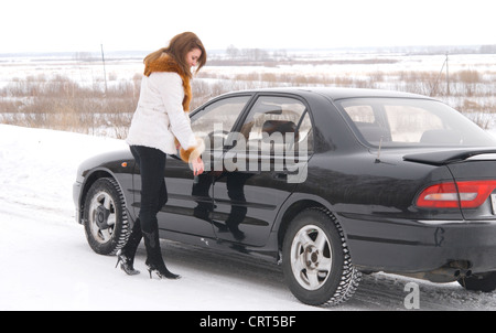 Giovane donna bella aprendo la sua automobile Foto Stock