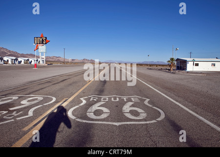 La storica Route 66 passa attraverso Amboy in California, Stati Uniti, con Roy's Diner visibile sulla sinistra dell'immagine. Foto Stock