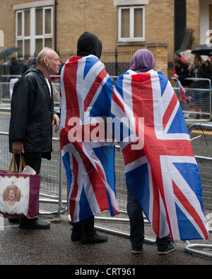 Da-standers indossando Union Jack Flag attendere per un assaggio della famiglia reale presso la Queen Elizabeth II di Diamante celebrazioni giubilari Foto Stock