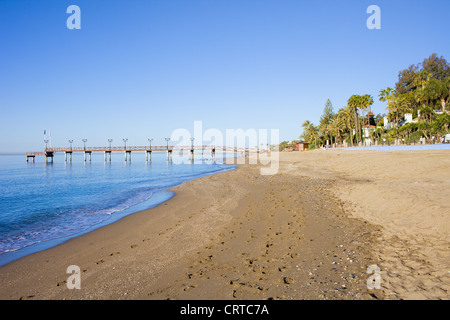Spiaggia e molo sulla Costa del Sol tra località di Marbella e Puerto Banus in Spagna, provincia di Malaga. Foto Stock