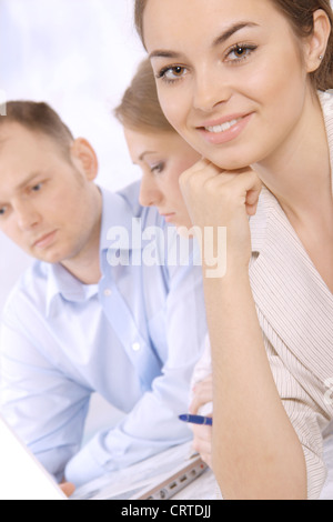 Gruppo di business di successo di colleghi in un incontro insieme a Office, con la messa a fuoco su un giovane dirigente aziendale Foto Stock