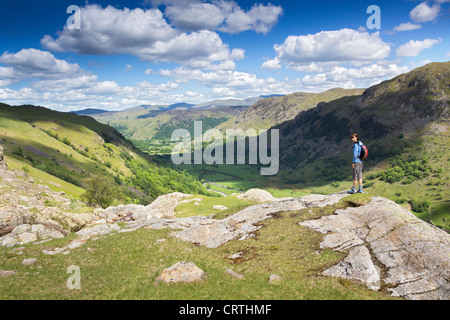 Un escursionista si avvicina Seathwaite attraverso il latte inacidito Gill in una giornata di sole nel distretto del lago, UK. Foto Stock