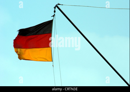 Sventolando, strappata bandiera della Germania nel vento Foto Stock