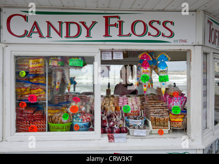 Negozio di dolci chiamati "Candy Floss' sul molo di Brighton con dolci sul display e la silhouette della ragazza giovane shop assistant Foto Stock