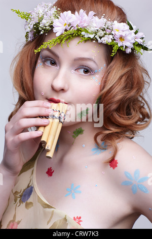 Redhead ragazza con flauti di pan Foto Stock