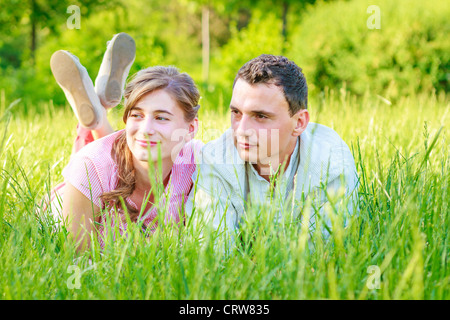 Allegro giovane bella giovane è disteso nel campo e godere la natura circostante. Foto Stock