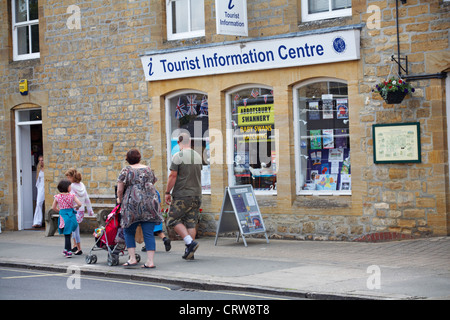 Famiglia passato a piedi al centro di informazioni turistiche a Sherborne, Dorset in giugno Foto Stock