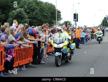 La polizia motociclista fiving alta o mano Tapa con gli spettatori per la Torcia Olimpica in halifax hx6 2np Regno Unito Foto Stock