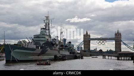 HMS Belfast con il Tower Bridge in background che mostra gli anelli olimpici. Foto Stock