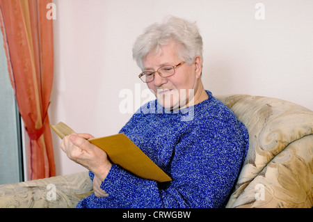 Donna anziana legge un libro Foto Stock