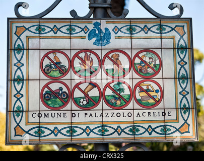 Un cartello in ceramica proibente all'ingresso dei giardini pubblici di Palazzolo Acreide, Sicilia meridionale, Italia Foto Stock