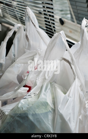 Shopping in plastica sacchi riempiti con gli acquisti sono impostati sul contatore prima di essere scaricati. Foto Stock