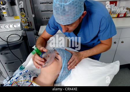 Un anestesista la somministrazione di gas medicali per mettere un paziente a dormire all'inizio di un'operazione. Foto Stock