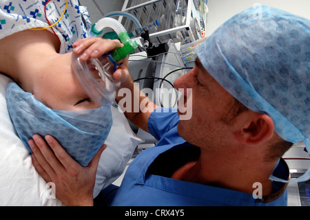 Un anestesista la somministrazione di gas medicali per mettere un paziente a dormire all'inizio di un'operazione. Foto Stock