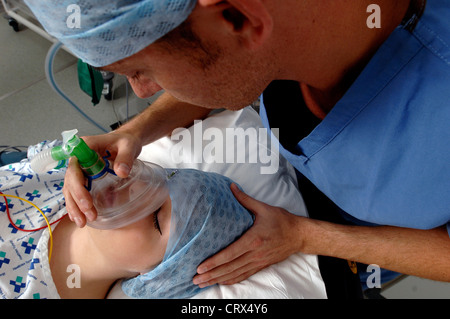 Un anestesista la somministrazione di gas medicali per mettere un paziente a dormire all'inizio di un'operazione. Foto Stock