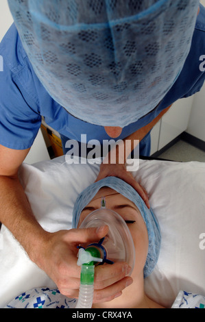 Un anestesista la somministrazione di gas medicali per mettere un paziente a dormire all'inizio di un'operazione. Foto Stock