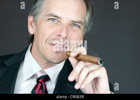 Close-up di un imprenditore di successo di fumare un sigaro. Foto Stock