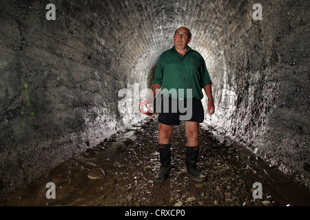 Bob Stewart all'interno della rotaia Spooners Tunnel su Tasmania di grande gusto Trail, Nelson, Nuova Zelanda. Foto Stock